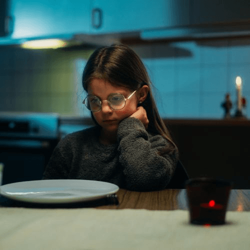 Picture of a girl sitting by an empty plate